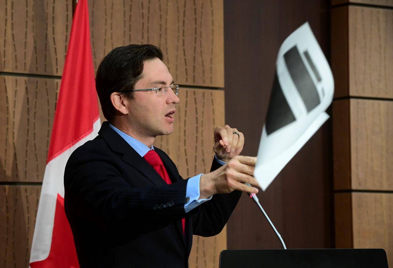 Conservative MP Pierre Poilievre throws a redacted document tabled at the House of Commons Finance Committee provided by the Government during a press conference on Parliament Hill in Ottawa on Wednesday, Aug. 19, 2020. THE CANADIAN PRESS/Sean Kilpatrick