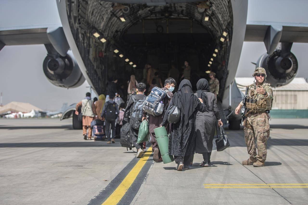 In this image provided by the U.S. Marine Corps, families begin to board a U.S. Air Force Boeing C-17 Globemaster III during an evacuation at Hamid Karzai International Airport in Kabul, Afghanistan, Monday, Aug. 23, 2021. THE CANADIAN PRESS/Sgt. Samuel Ruiz/U.S. Marine Corps via AP