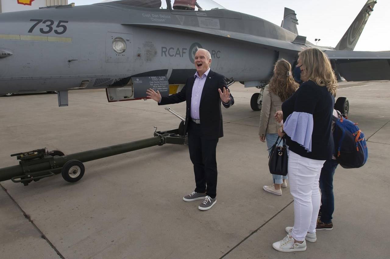 Conservative Leader Erin O'Toole, his wife, Rebecca, and their children check out a CF-18 Hornet parked near their campaign plane as they arrive in Edmonton, Saturday, Aug. 21, 2021. THE CANADIAN PRESS/Ryan Remiorz