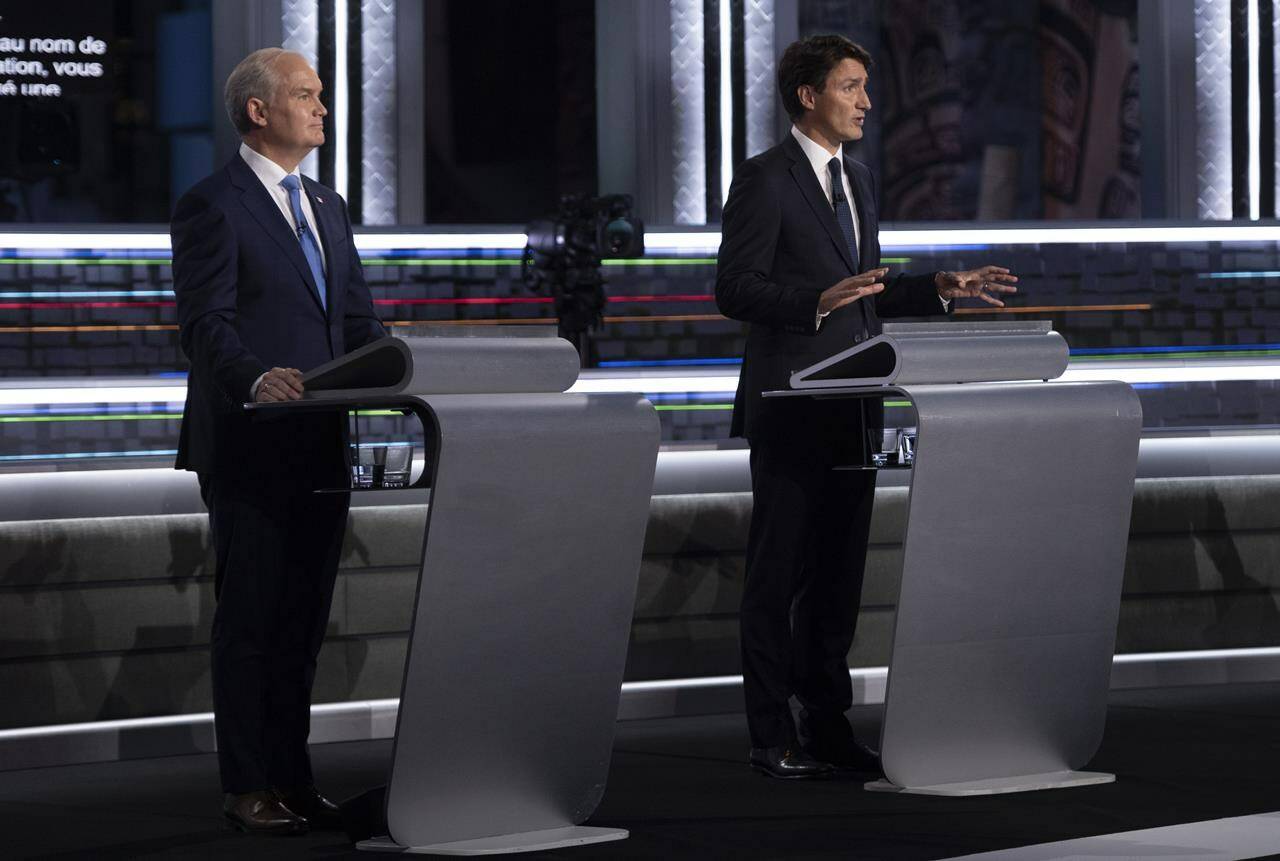 Conservative leader Erin O’Toole listens to Liberal leader Justin Trudeau during the federal election French-language leaders debate in Gatineau, Que., Wednesday, Sept. 8, 2021. A new poll shows a complete deadlock between Justin Trudeau’s Liberals and Erin O’Toole’s Conservatives with less than one week left in the federal election. THE CANADIAN PRESS/Justin Tang