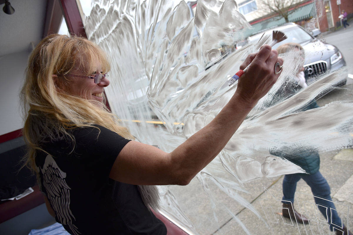 Kath Stroman paints the window at the former site of Barb’s Kitchen on First Avenue. The local artist was commissioned by the Ladysmith Downtown Business Association to bring new life to the building in advance of this week’s 30th annual Festival of Lights celebration. (Mike Gregory Photo).