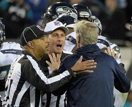 Seattle Seahawks head coach Pete Carroll is held back by officials after he ran on the field during the final moments of an NFL football game Sunday, Dec. 10, 2017, in Jacksonville, Fla. Jacksonville won 30-24. Carroll got flagged for coming onto the field. (AP Photo)