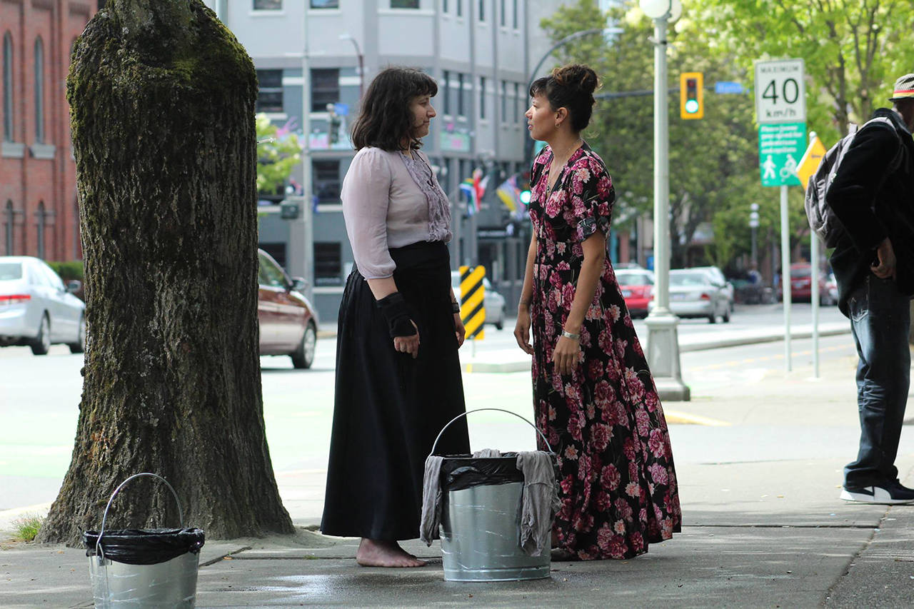 Victoria’s Indigenous Artist in Residence Lindsay Delaronde (right) in collaboration with Pascalle Ellefsen, entitled “We Bring Medicine to the Streets,” in which the artists washed Pandora street during a street performance. (Facebook)