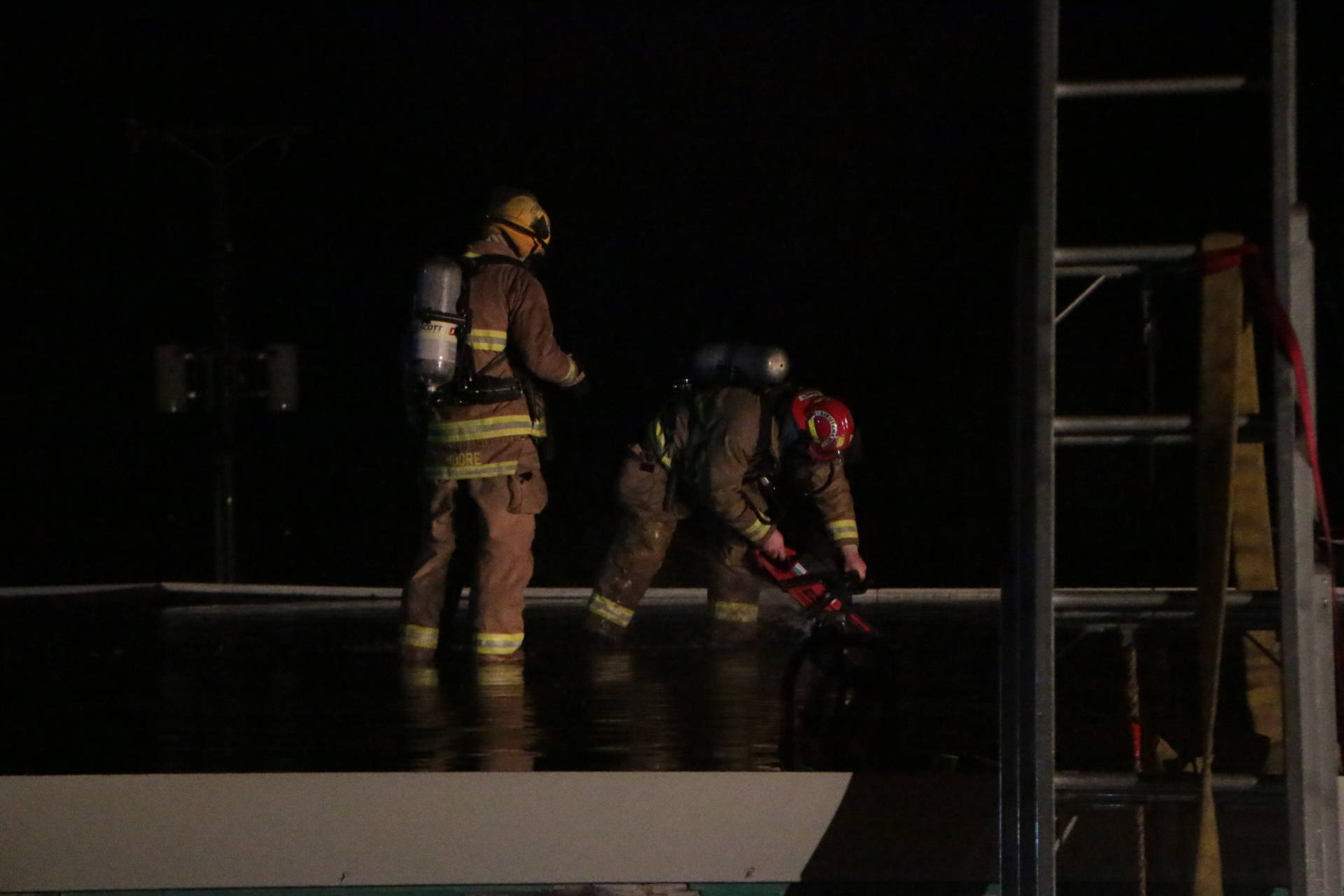 Firefighters cut into the roof of the old Crofton School building while battling a blaze on Friday night. (Kevin Rothbauer/Citizen)