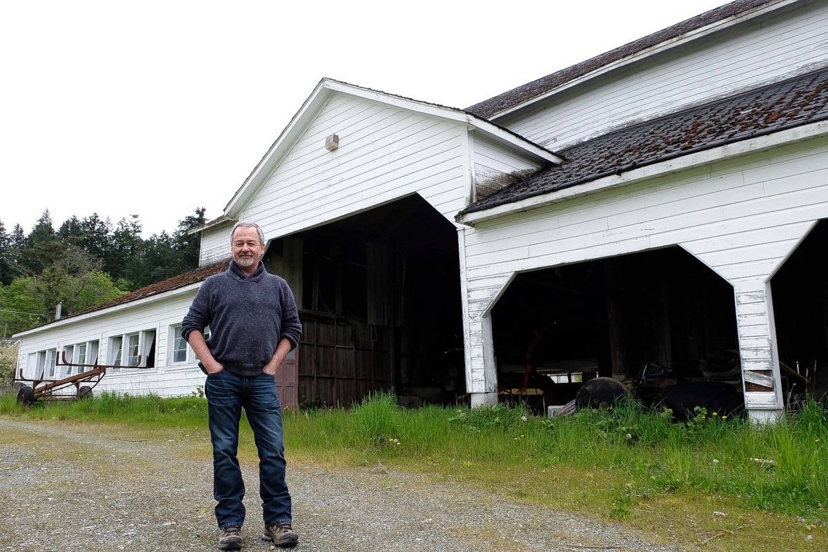 Richard Leblanc, executive director of the Creating Homefulness Society, stands in front of the East Barn. (Alisa Howlett/News Staff file photo)
