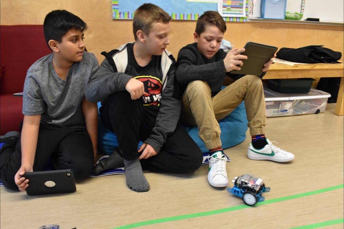 Manak, Hudson and Tyler control a robot they built themselves. (Sam Anderson)
