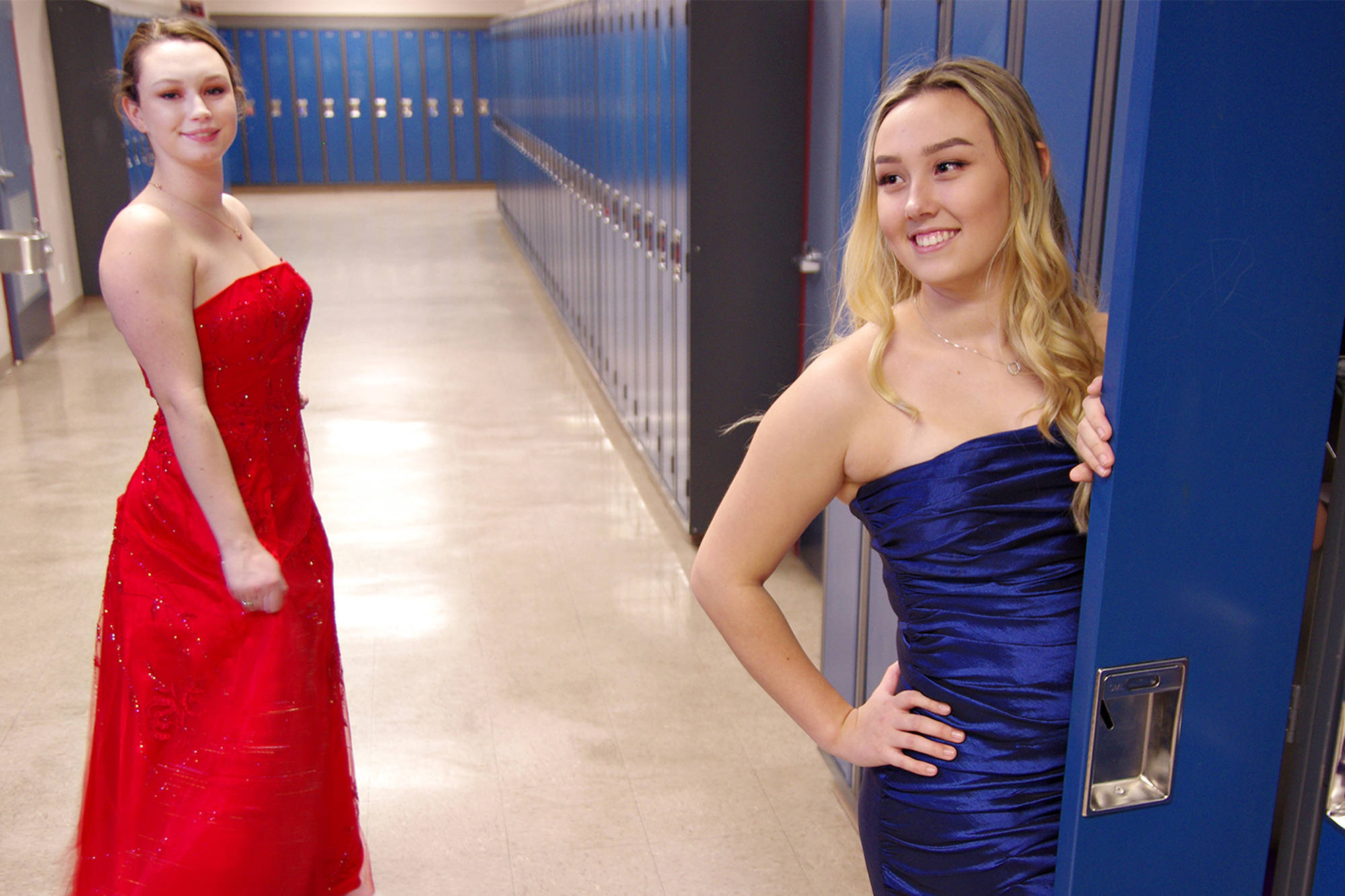 Wellington Secondary School Grade 12 students Emma Campbell, left, and Holly Cochrane show off a couple of dress samples available from Prom Closet Nanaimo. The non-profit has about 400 prom dresses in all colours, styles and sizes, which it will offer free to graduating teens. CHRIS BUSH/The News Bulletin