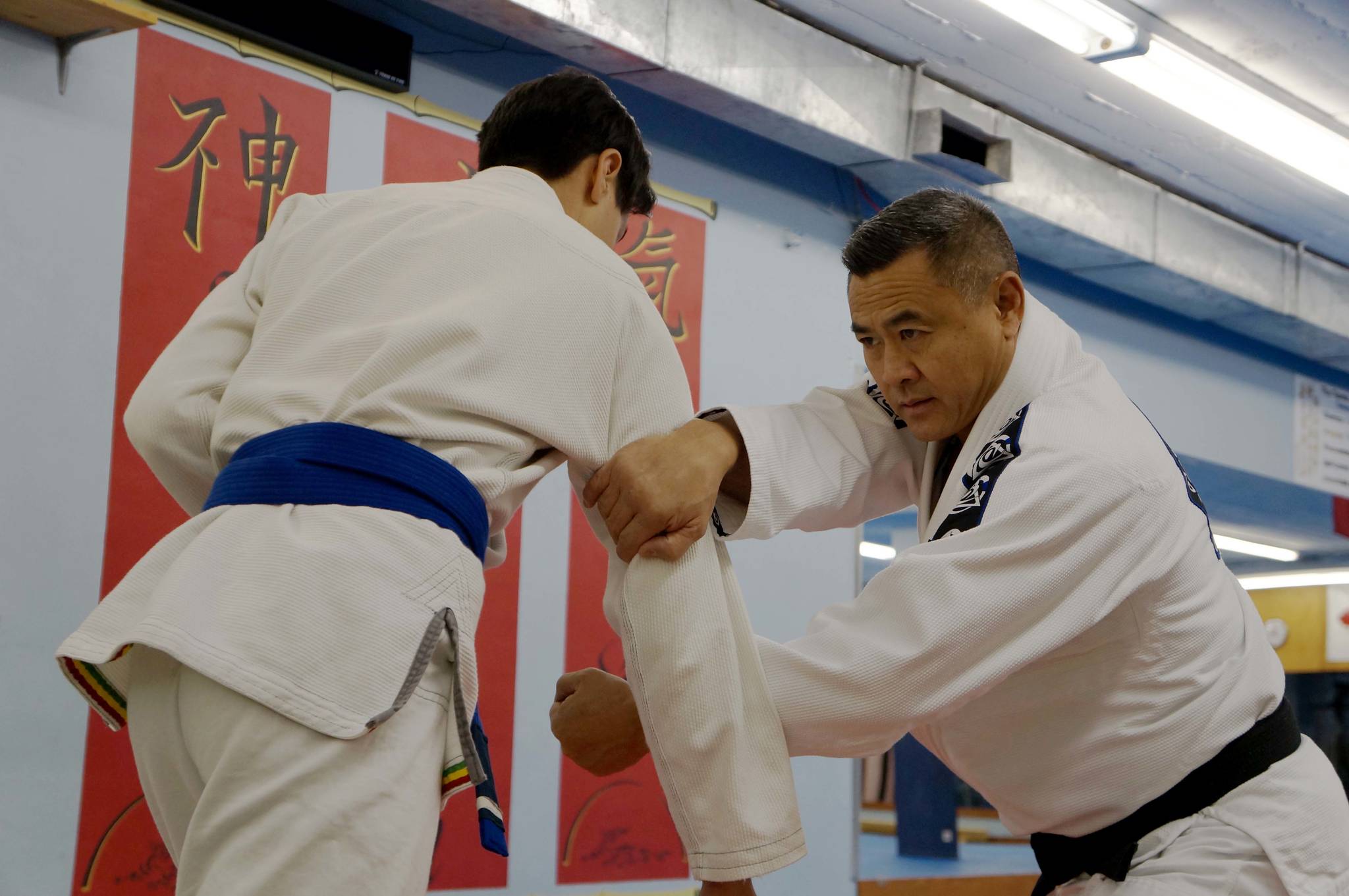 Warren Lee, right, practices jiu-jitsu moves with his 17-year-old son Carter in his Port Alberni academy. KARLY BLATS PHOTO