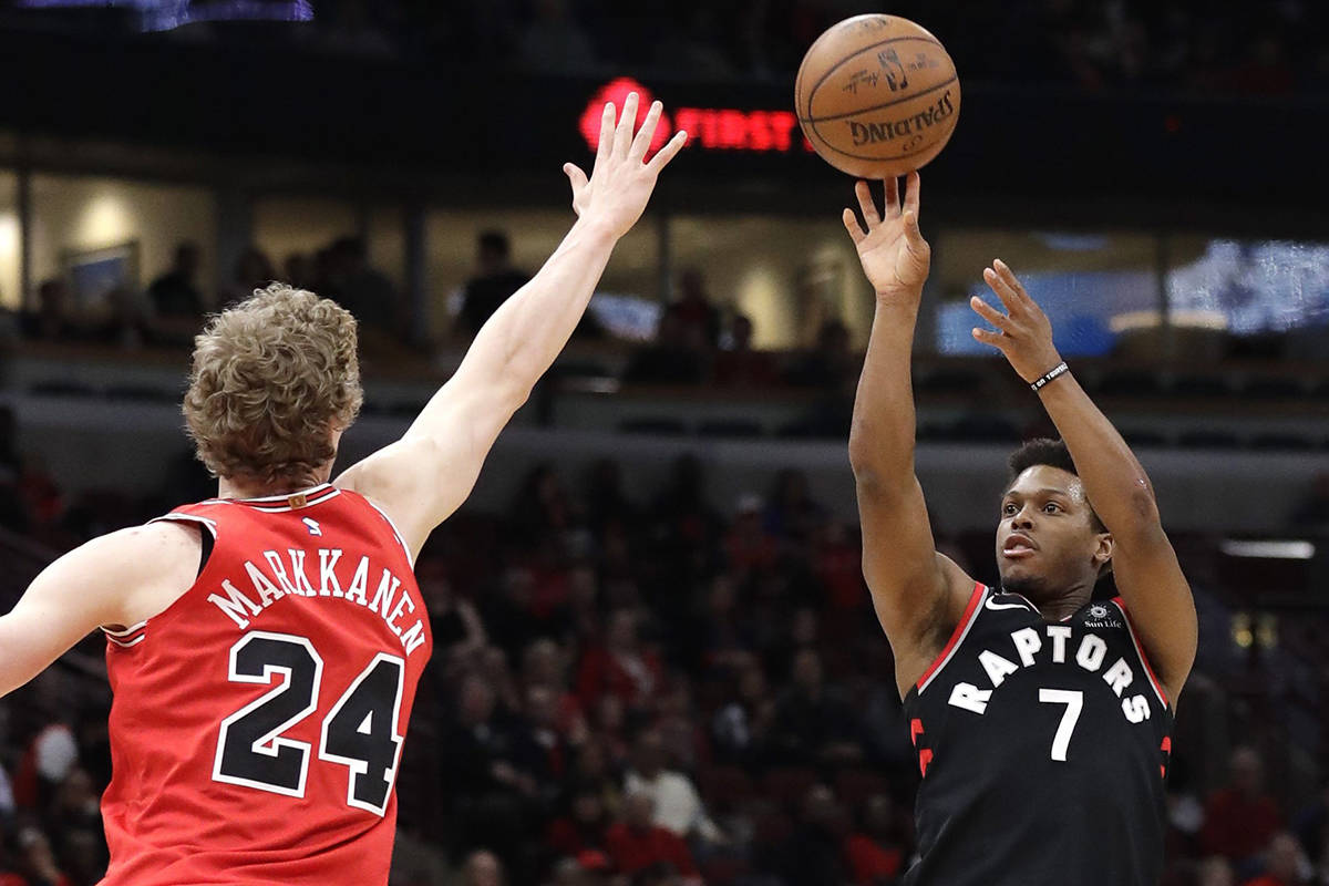 Toronto Raptors guard Kyle Lowry, right, shoots against Chicago Bulls forward Lauri Markkanen during the first half of an NBA basketball game Wednesday, Feb. 14, 2018, in Chicago. (AP Photo/Nam Y. Huh)