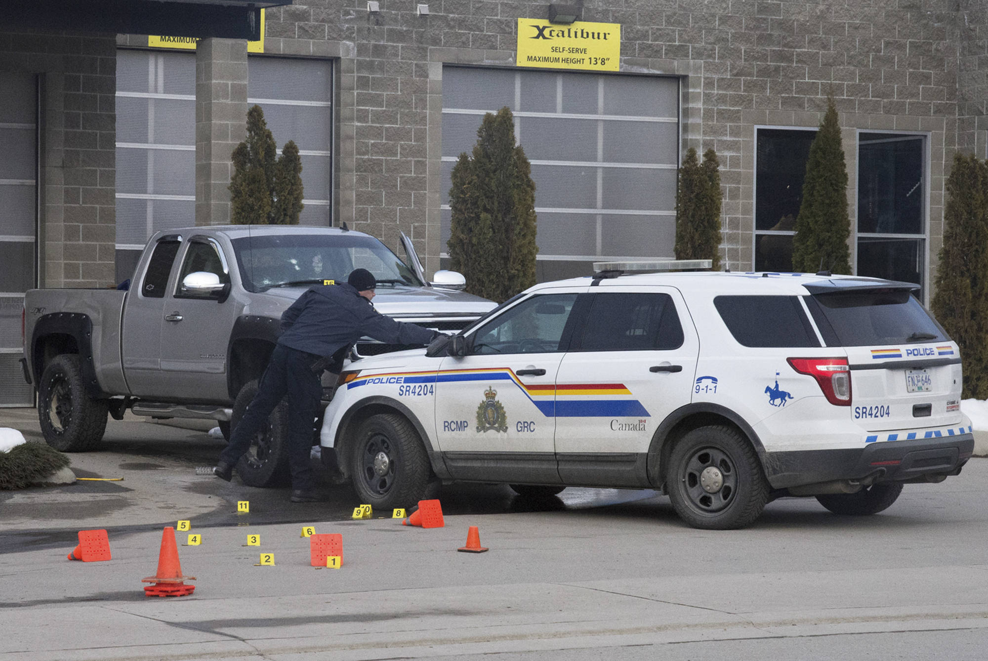 Investigators mark the location of spent bullet casings and gunshot marks on the vehicles involved in the Jan. 30 shooting at the Xcalibur car wash in Salmon Arm. (Jim Elliot/Salmon Arm Observer)