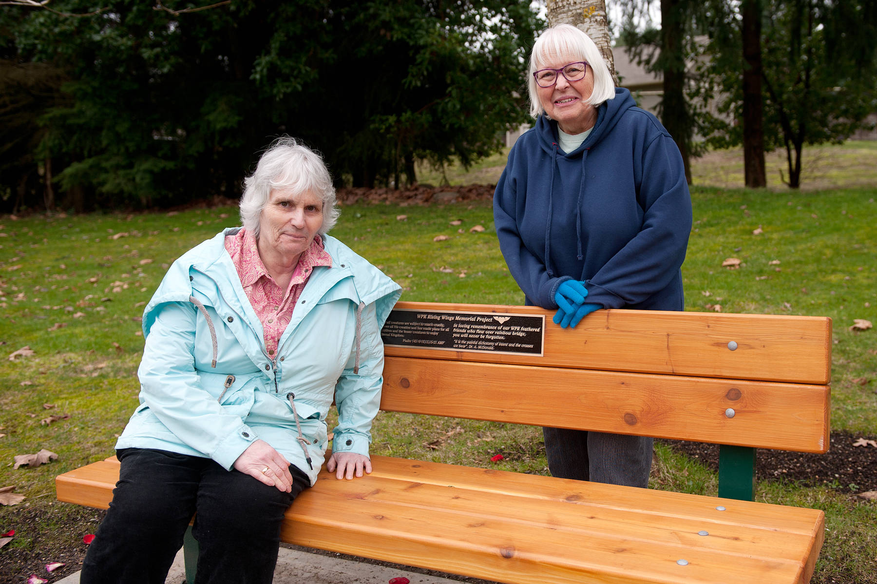Dr. Anne McDonald, seated, and World Parrot Refuge Rising Wings Memorial Project chair Gloria Fantin meet at the memorial bench they helped install at Parksville’s railroad station park in February, 2018. — J.R. Rardon photo