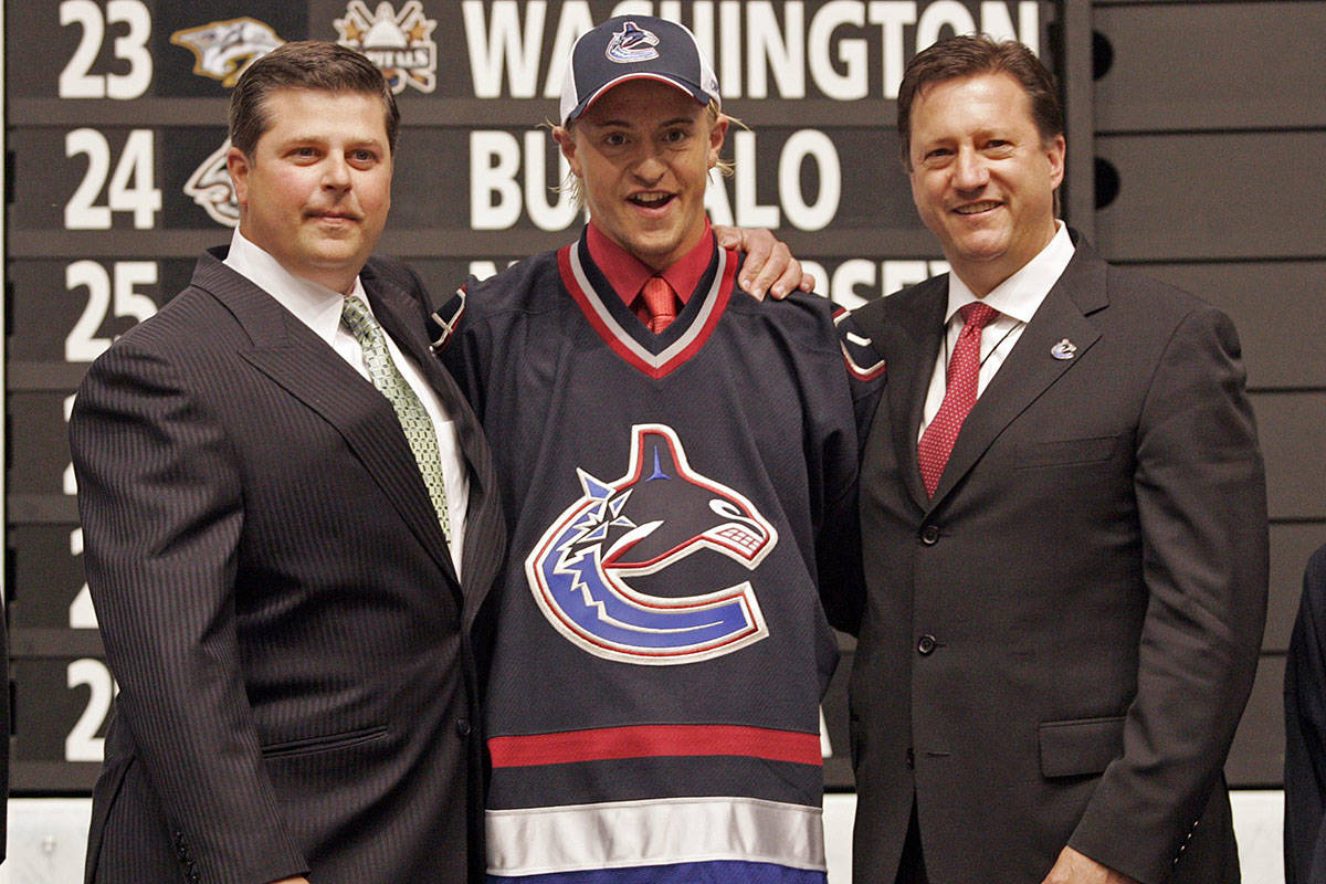 Michael Grabner (centre) poses for a photo with Vancouver Canucks general manager Dave Nonis (left) and Steve Tambellini after the Canucks selected Grabner with the 14th overall pick in the 2006 NHL Entry Draft in Vancouver, B.C., Saturday, June 24, 2006. (CP PHOTO/Chuck Stoody)