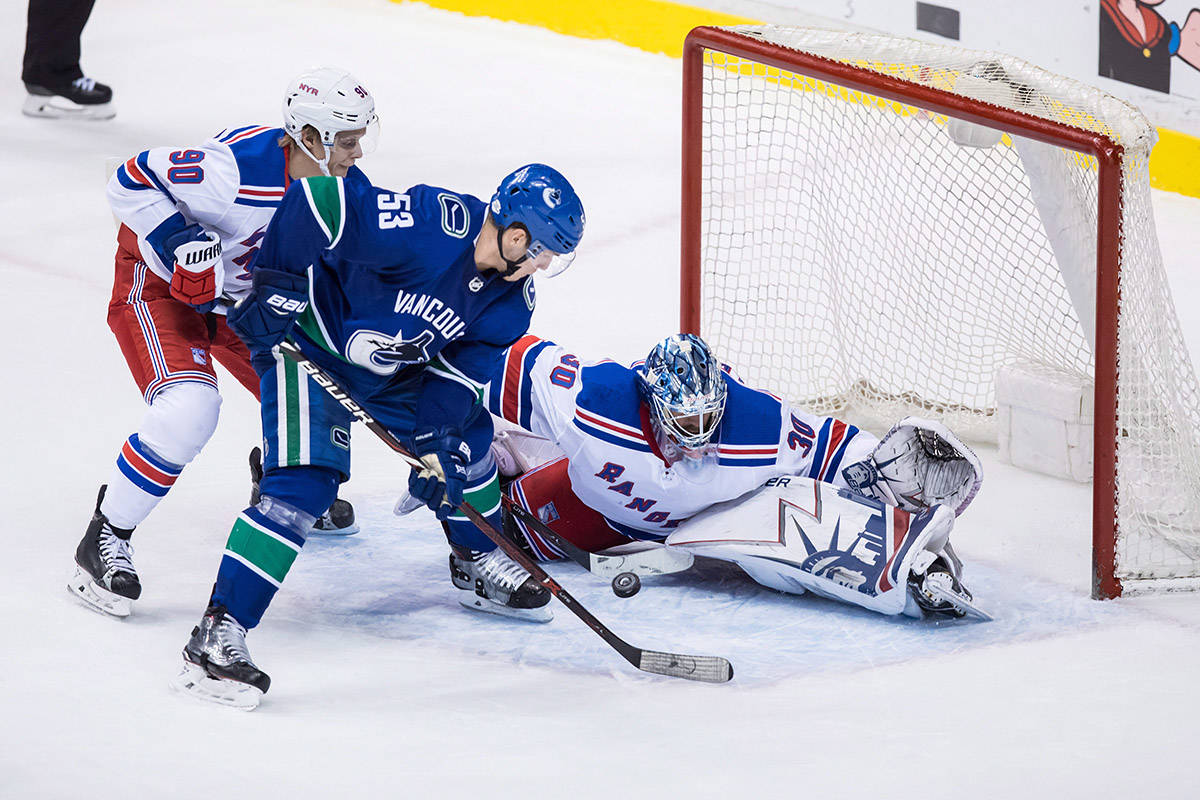 Vancouver Canucks’ Bo Horvat (53) is stopped by New York Rangers’ goalie Henrik Lundqvist, right, of Sweden, while being checked by Vladislav Namestnikov (90), of Russia, during the second period of an NHL hockey game in Vancouver, B.C., on Wednesday February 28, 2018. THE CANADIAN PRESS/Darryl Dyck