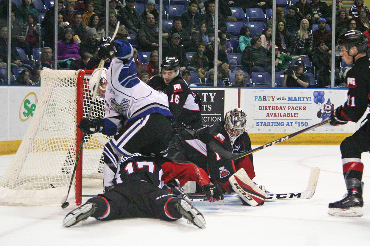 Victoria Royals captain Matthew Phillips (in white) and his teammates dropped a 2-1 overtime decision to Prince George last night and meet the Cougars in the Interior city again tonight. The single point in Western Hockey League action clinched a playoff berth for the Royals. Don Descoteau/Victoria News
