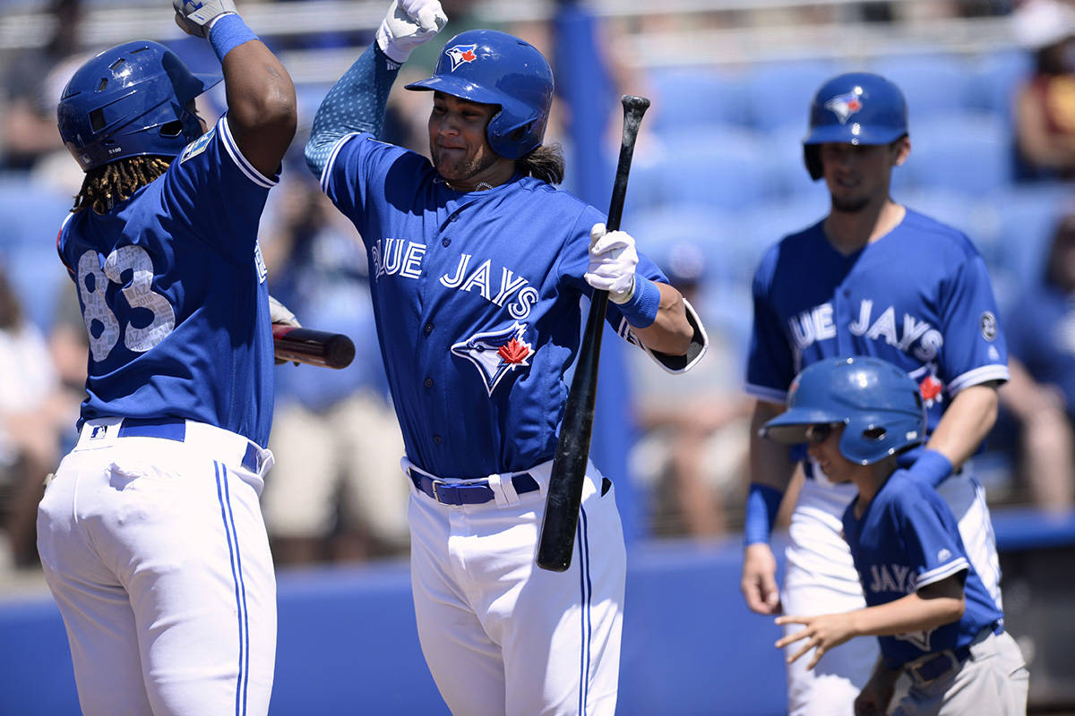 Toronto Blue Jays Vladimir Guerrero Jr., left, and Bo Bichette, right, celebrate after Bichette’s two-run home run during the first inning of a spring training baseball game against the Canada Junior National Team Saturday, March 17, 2018, in Dunedin, Fla. (AP Photo/Jason Behnken)