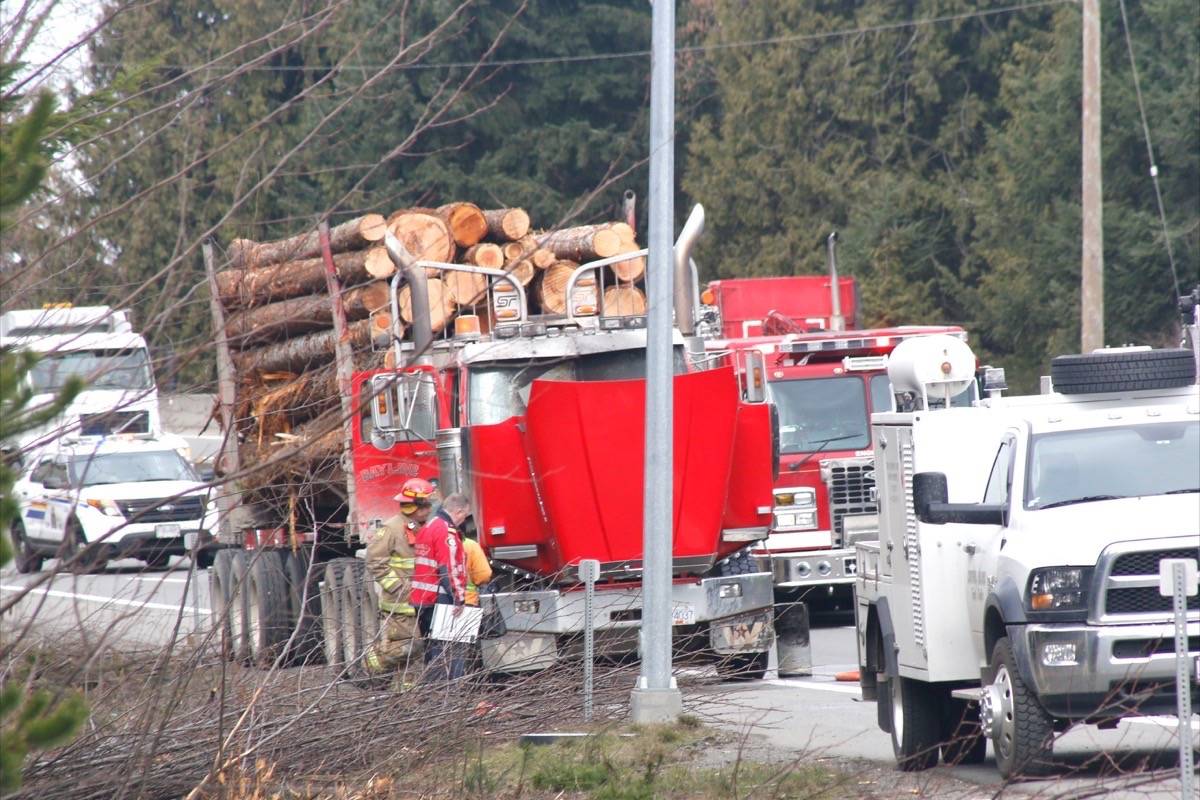 A Parksville firefighter looks into the engine compartment of a logging truck, which had been smoking minutes before, on southbound Highway 19 just north of the weigh scales after firefighters we called to a logging truck fire Tuesday, March 20. — Adam Kveton Photo
