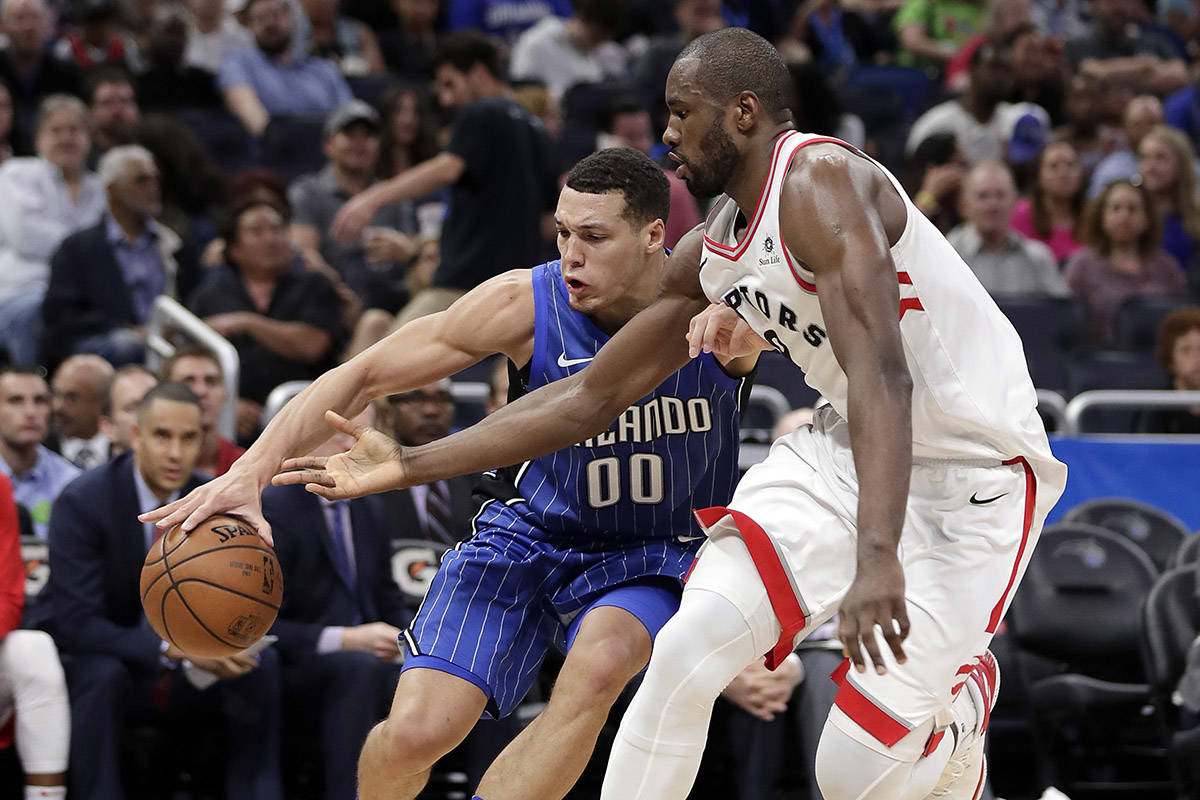 Orlando Magic&rsquo;s Aaron Gordon (00) tries to get around Toronto Raptors&rsquo; Serge Ibaka during the second half of an NBA basketball game, Tuesday, March 20, 2018, in Orlando, Fla. (AP Photo/John Raoux)