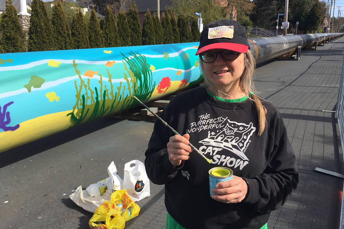 Local painter Teresa Waclawik is doing her best to brighten up the dreary situation along Niagara Street, painting a mural on the sewage pipe currently being staged in the neighbourhood as part of construction on the McLoughlin Point Wastewater Treatment Plant. Kristyn Anthony/VICTORIA NEWS