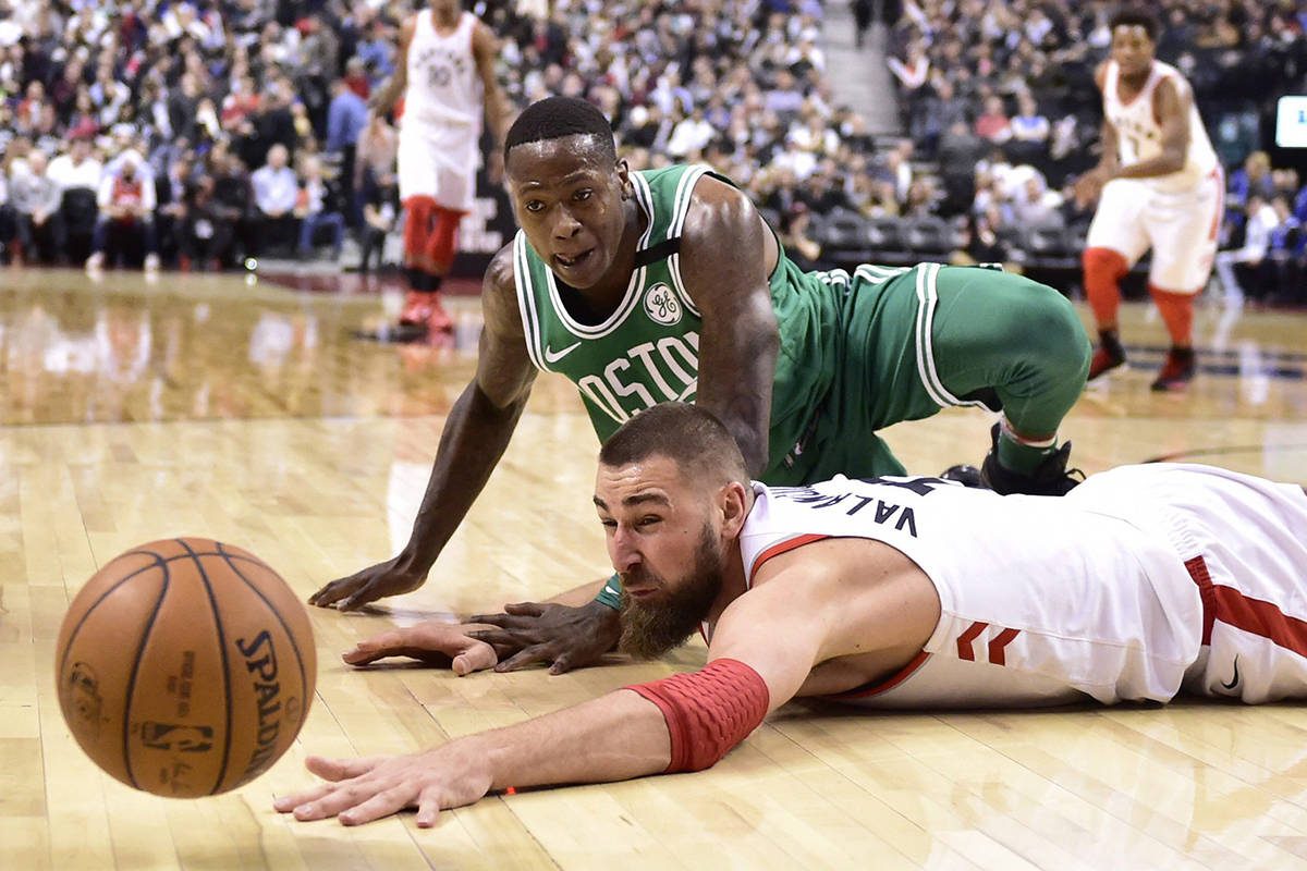 Toronto Raptors centre Jonas Valanciunas (17) and Boston Celtics guard Terry Rozier (12) eye a loose ball during second half NBA basketball action in Toronto on Wednesday, April 4, 2018. THE CANADIAN PRESS/Frank Gunn