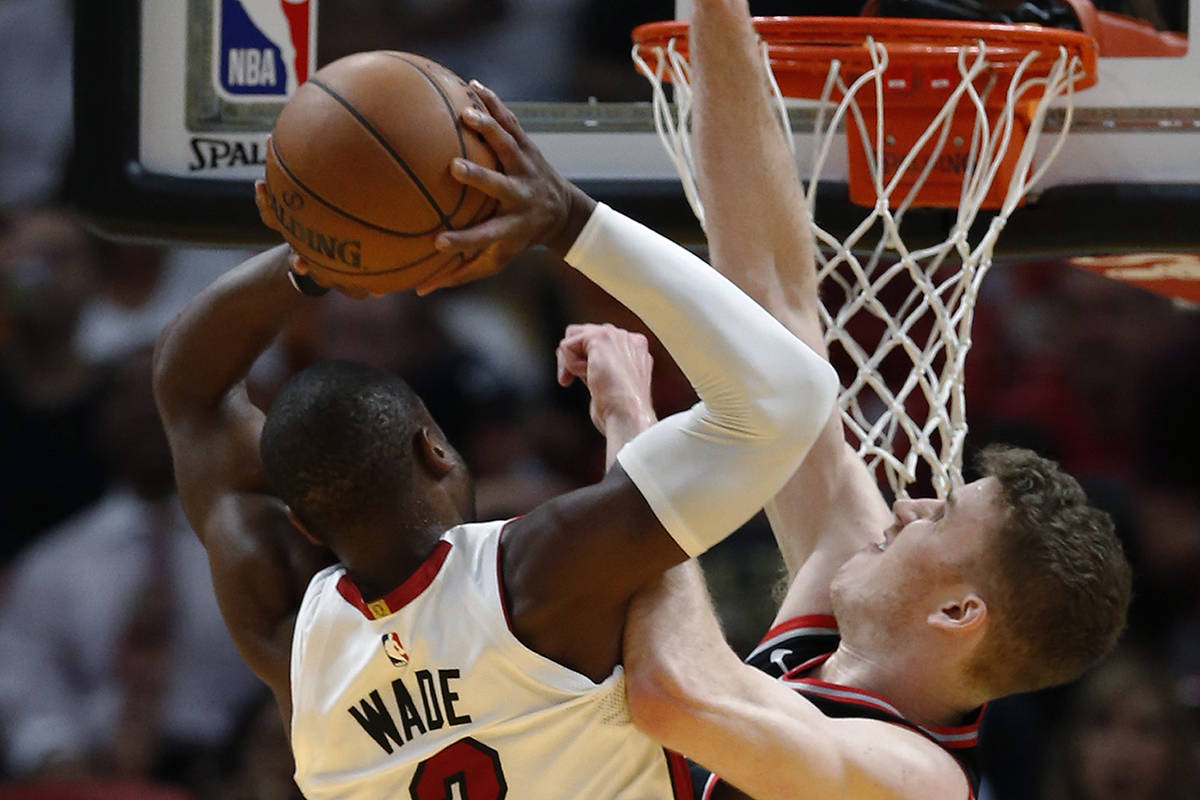 Miami Heat guard Dwyane Wade (3) goes up for a shot against Toronto Raptors center Jakob Poeltl (42) during the first half of an NBA basketball game Wednesday, April 11, 2018, in Miami. (AP Photo/Wilfredo Lee)