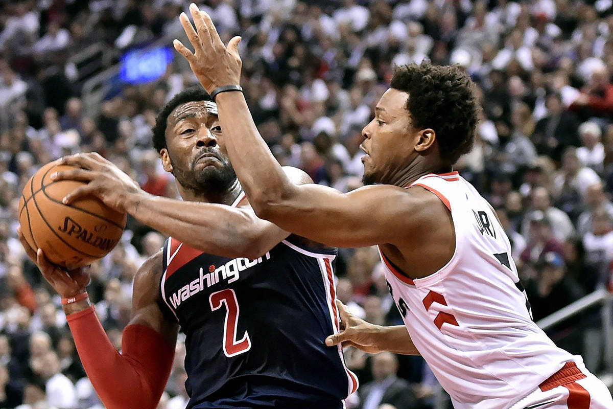 Washington Wizards guard John Wall (2) looks to drive to the net as Toronto Raptors guard Kyle Lowry (7) pressures during second half NBA basketball action in Toronto on Tuesday, April 17, 2018. THE CANADIAN PRESS/Nathan Denette