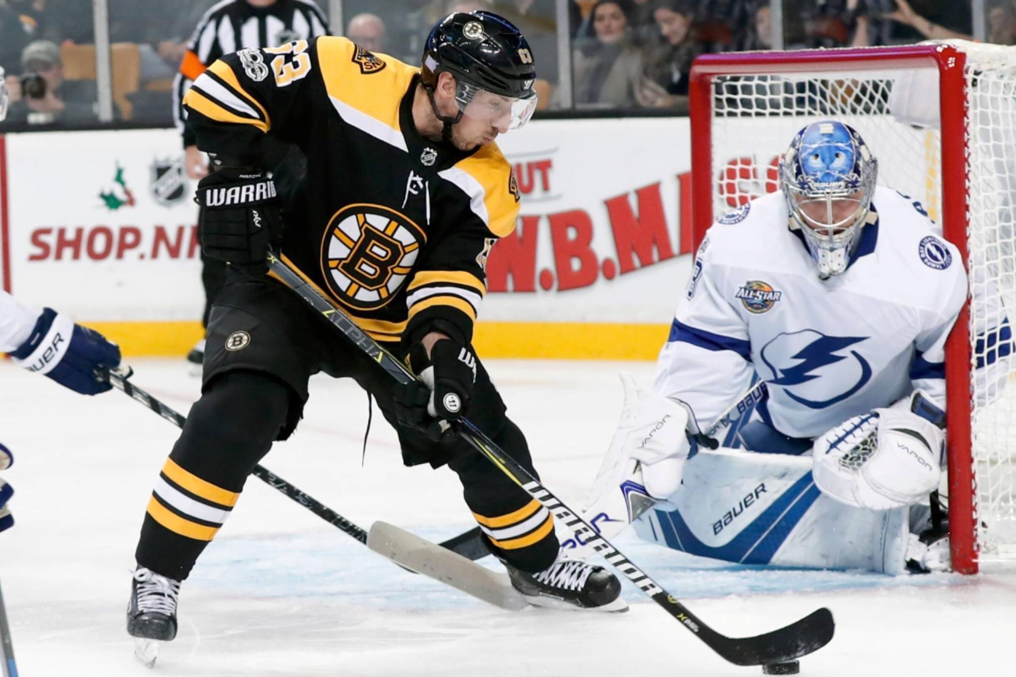 Boston Bruins forward Brad Marchand corrals the puck in front of Tampa Bay Lightning netminder Andrei Vasilevskiy during the regular season. Both teams are set to face each other in the second round of the NHL Stanley Cup playoffs Saturday at 12 p.m. in Tampa, Fl. (via @NHLBruins/Twitter)