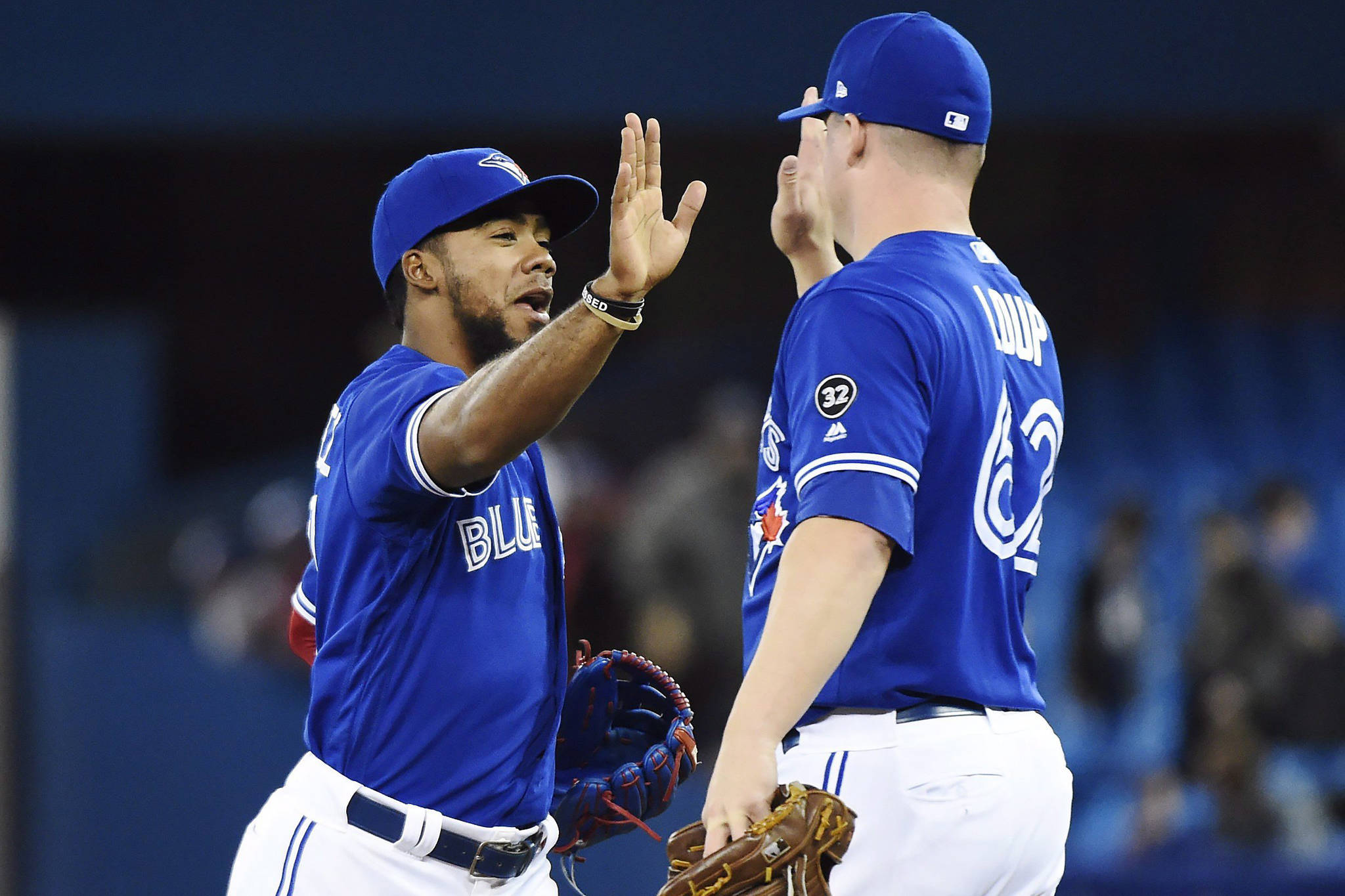 Toronto Blue Jays left fielder Teoscar Hernandez, left, and Blue Jays relief pitcher Aaron Loup (62) celebrate after defeating the Texas Rangers in AL baseball action in Toronto on Sunday, April 29, 2018. THE CANADIAN PRESS/Nathan Denette