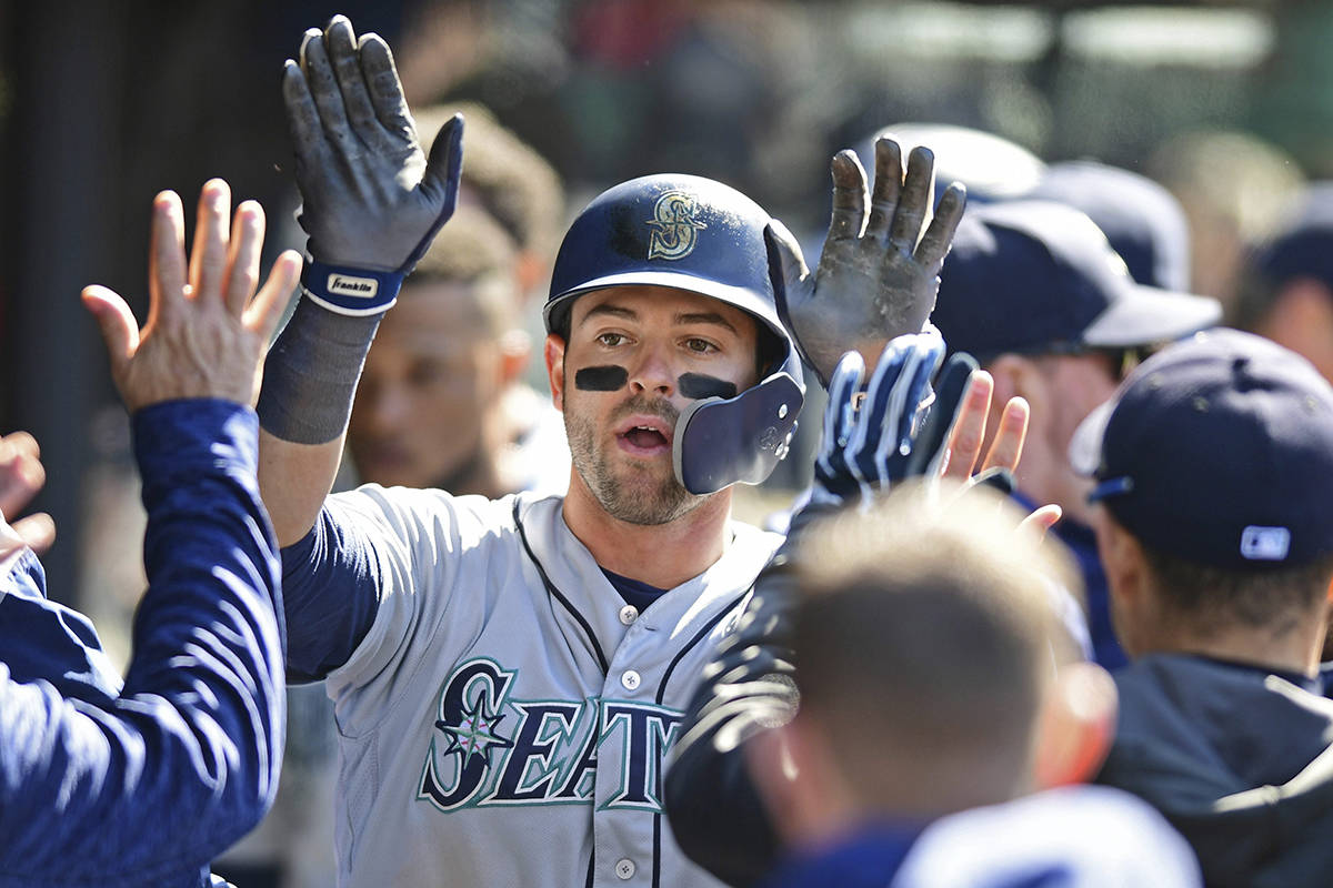 Seattle Mariners’ Mitch Haniger is congratulated in the dugout after hitting a solo home run off Cleveland Indians relief pitcher Zach McAllister in the ninth inning of a baseball game, Sunday, April 29, 2018, in Cleveland. (AP Photo/David Dermer)