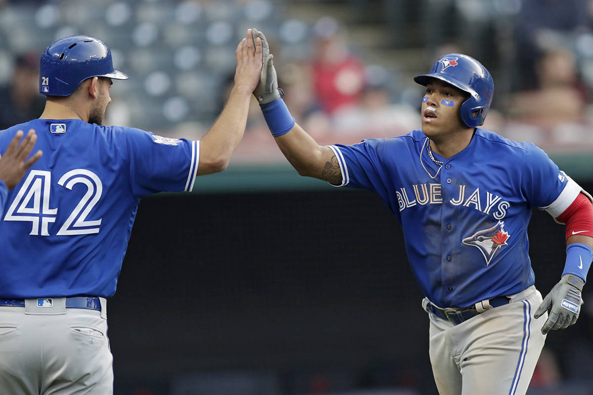 Toronto Blue Jays’ Yangervis Solarte, right, is congratulated by Luke Maile after Solarte hit a grand slam in the 11th inning in the first game of a baseball doubleheader against the Cleveland Indians, Thursday, May 3, 2018, in Cleveland. The Blue Jays won 13-11 in 11 innings. (AP Photo/Tony Dejak)