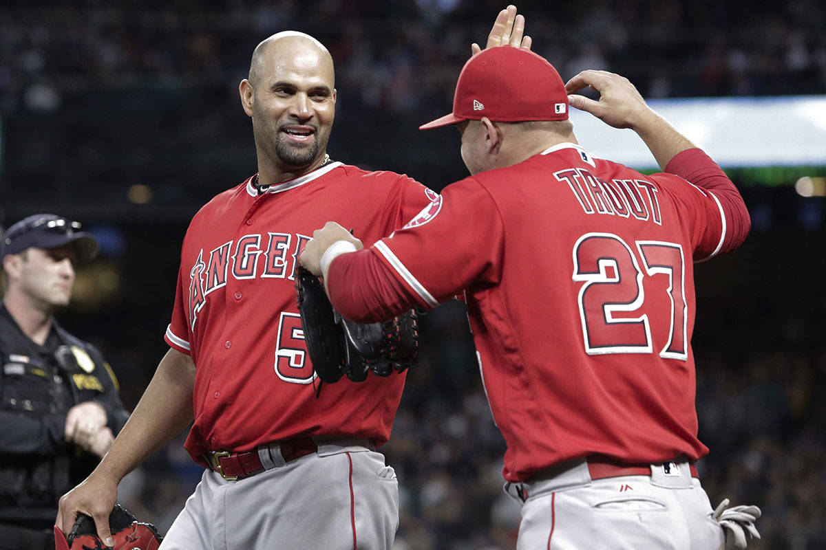 Los Angeles Angels’ Albert Pujols celebrates with Mike Trout between the top and bottom of the fifth inning after Pujols singled for his 3,000th career hit, against the Seattle Mariners in a baseball game Friday, May 4, 2018, in Seattle. (AP Photo/Jason Redmond)