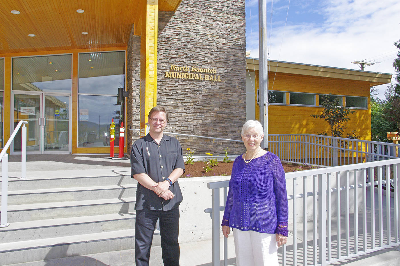 District of North Saanich CAO Rob Buchan and Mayor Alice Finall stand at the entrance to the new municipal hall building on Mills Road. (Steven Heywood/News staff)