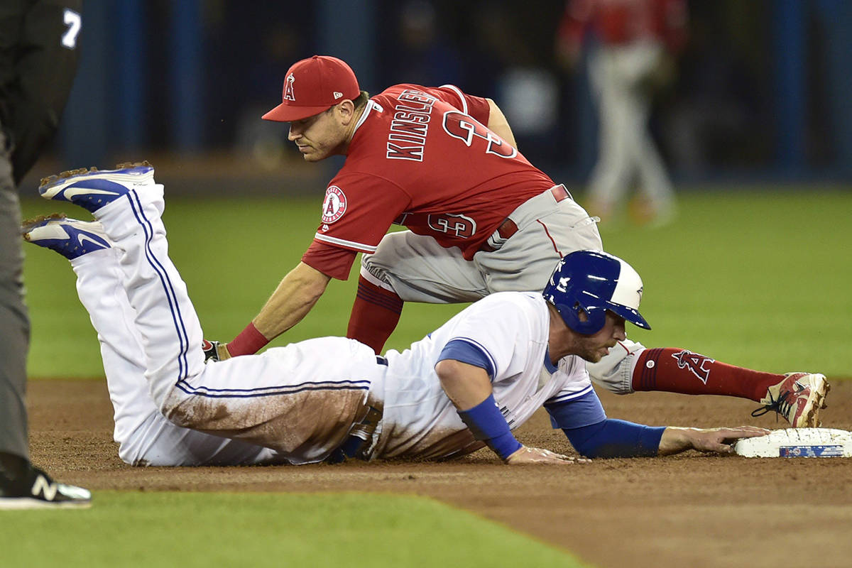 Toronto Blue Jays first baseman Justin Smoak (14) makes it back to second as Los Angeles Angels second baseman Ian Kinsler (3) misses the tag after teammate Jays centre fielder Kevin Pillar (11) lined out to third in first inning American League baseball action in Toronto on Tuesday, May 22, 2018. THE CANADIAN PRESS/Frank Gunn