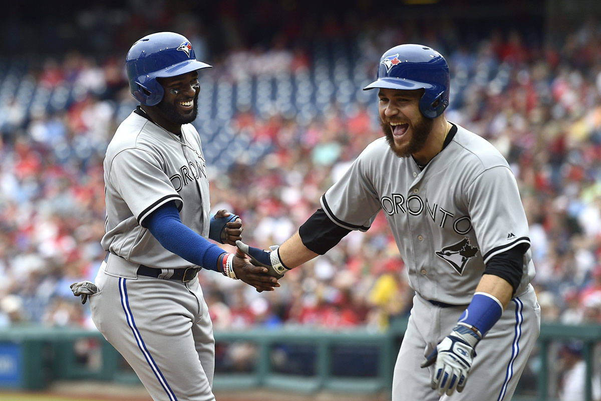 Toronto Blue Jays’ Russell Martin, right, and Dwight Smith Jr. high-five after scoring on a Devon Travis double off Philadelphia Phillies’ Nick Pivetta during the second inning of a baseball game, Sunday, May 27, 2018, in Philadelphia. (AP Photo/Derik Hamilton)