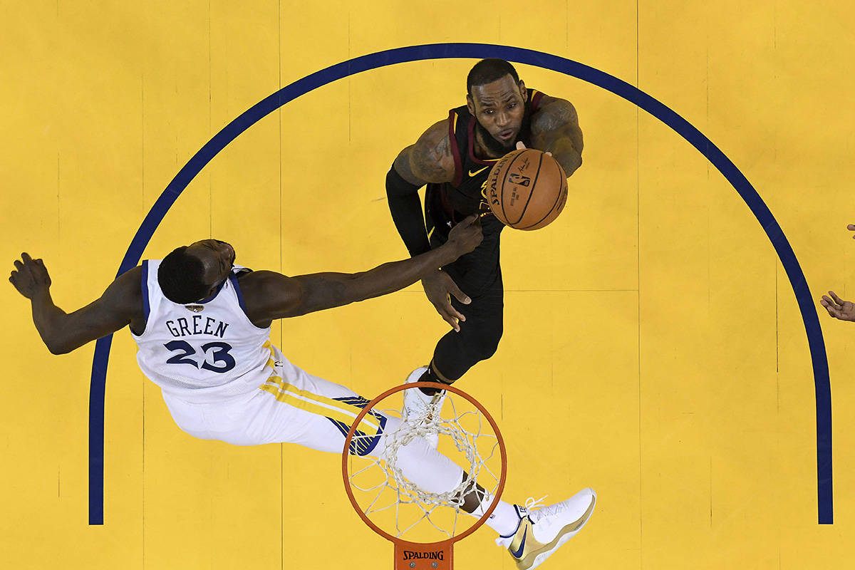 Cleveland Cavaliers forward LeBron James, top, shoots against Golden State Warriors forward Draymond Green during the second half of Game 1 of basketball’s NBA Finals in Oakland, Calif., Thursday, May 31, 2018. The Warriors won 124-114 in overtime. (Kyle Terada/Pool Photo via AP)