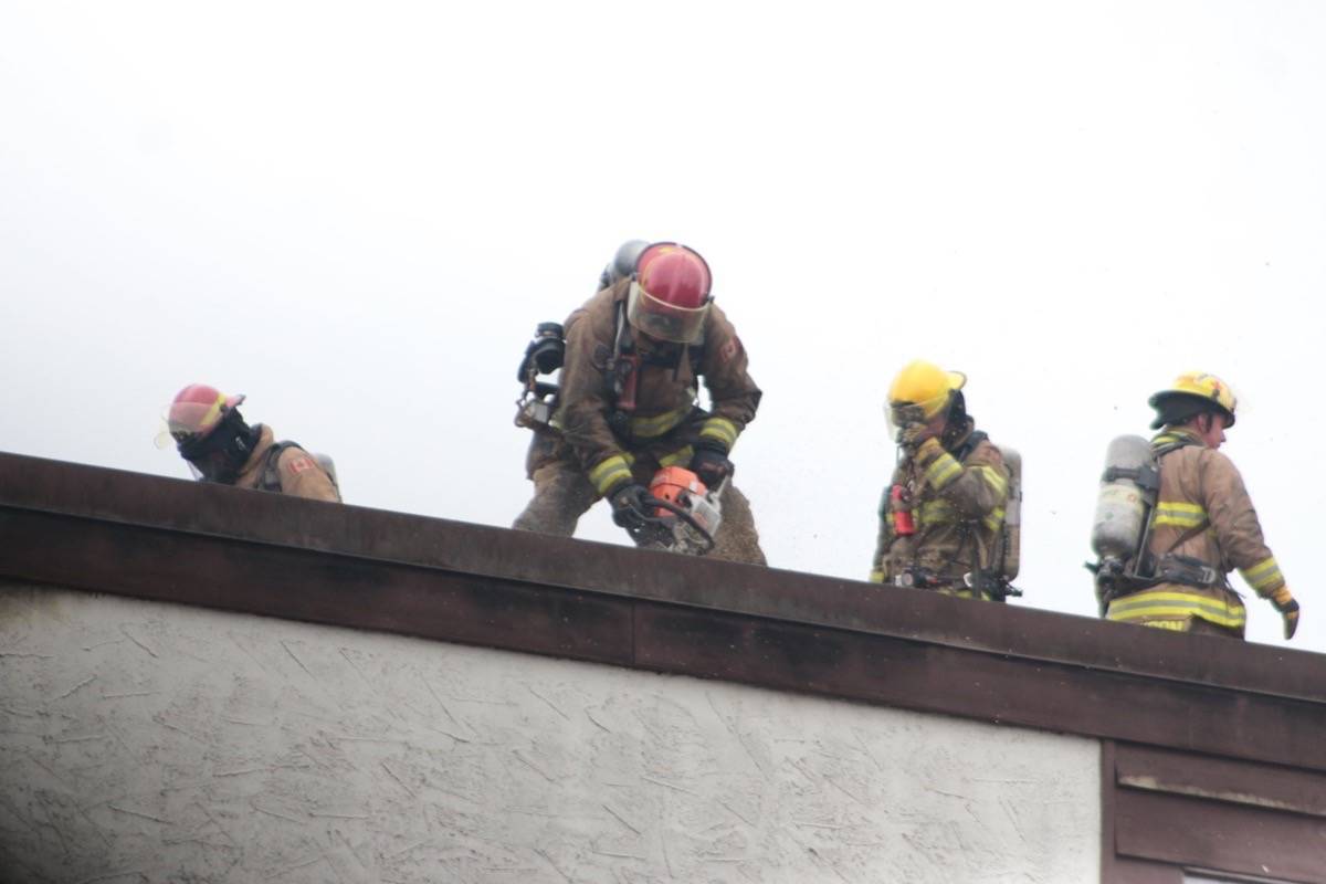 Firefighters work on the roof at Parkland Apartments. (Kevin Rothbauer/Citizen)