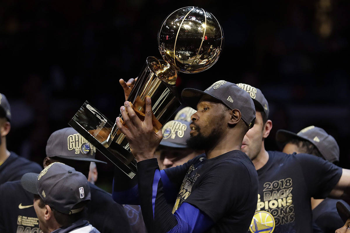 Golden State Warriors’ Kevin Durant celebrates with the trophy after the Warriors defeated the Cleveland Cavaliers 108-85 in Game 4 of basketball’s NBA Finals to win the NBA championship, Friday, June 8, 2018, in Cleveland. (AP Photo/Tony Dejak)