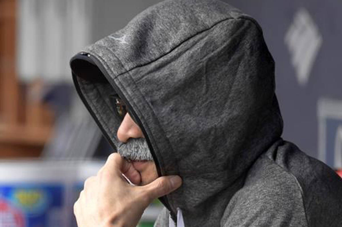 Ichiro Suzuki, special assistant to the chairman of the Seattle Mariners, wears a fake mustache and a hoodie as he sits in the dugout and watches the New York Yankees bat during the first inning of a baseball game Thursday, June 21, 2018, at Yankee Stadium in New York. Suzuki donned a Bobby Valentine-style disguise and sneaked into the Seattle dugout to watch a bit of the action. (AP Photo/Bill Kostroun)