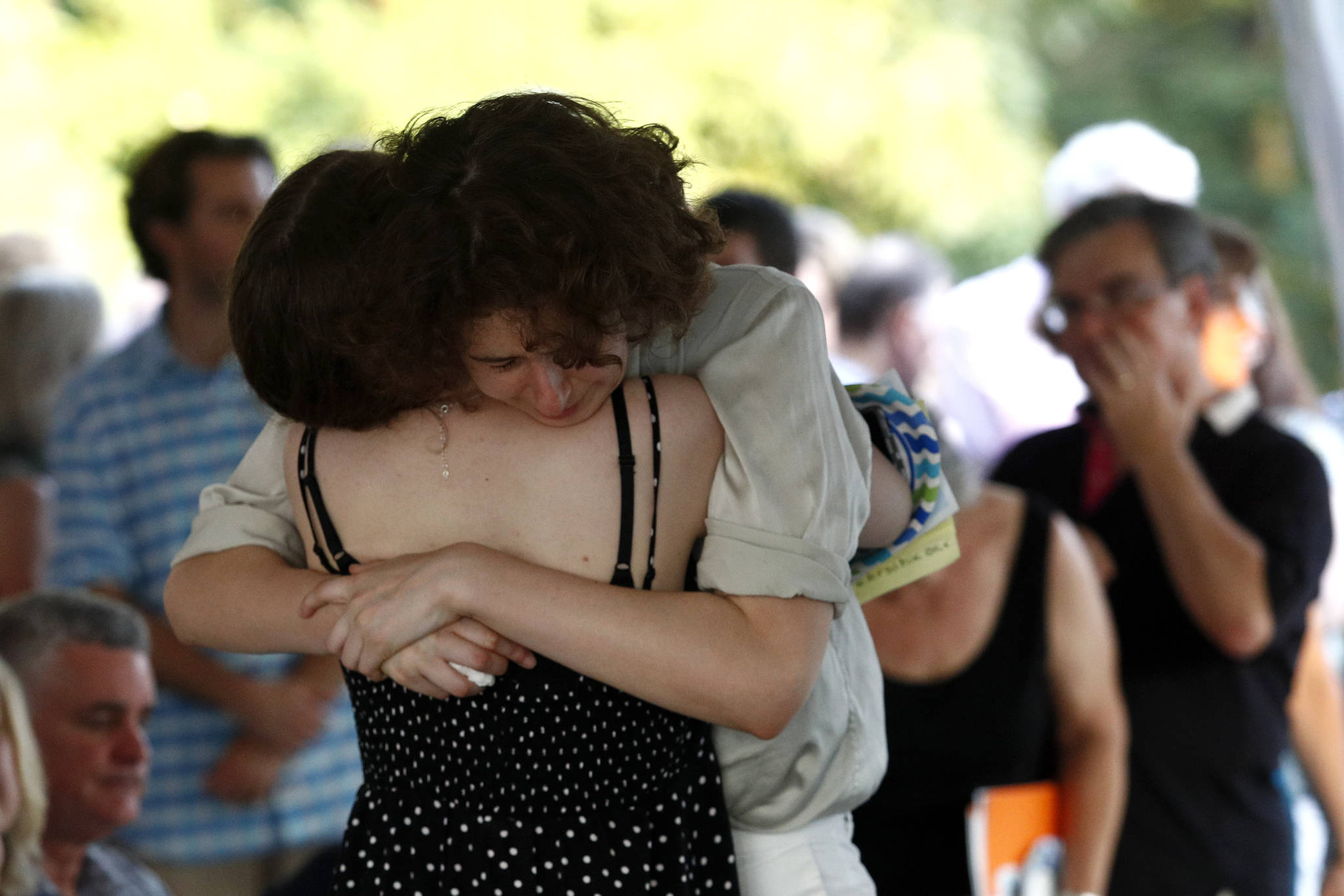 Hannah Hiaasen, center right, hugs her sister Sam following a memorial service for their father, Rob Hiaasen, one of the journalists killed in the shooting at The Capital Gazette newspaper offices, Monday, July 2, 2018, in Owings Mills, Md. (AP Photo/Patrick Semansky)