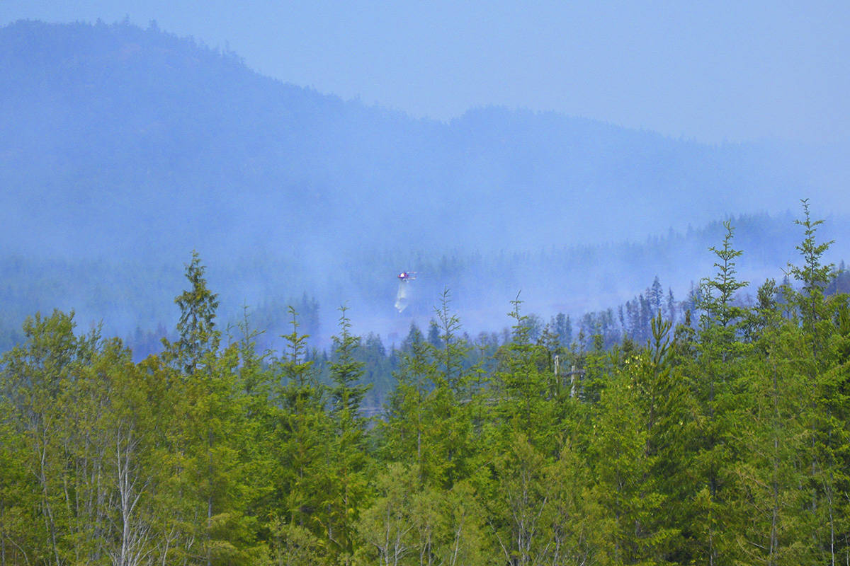 A helicopter drops water on the Tugwell Creek Fire. (Photo by Ken Groat)