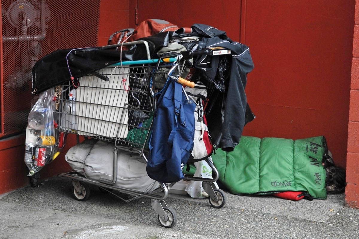 A man sleeps at vacant commercial property in downtown Victoria. (Tom Fletcher/Black Press)
