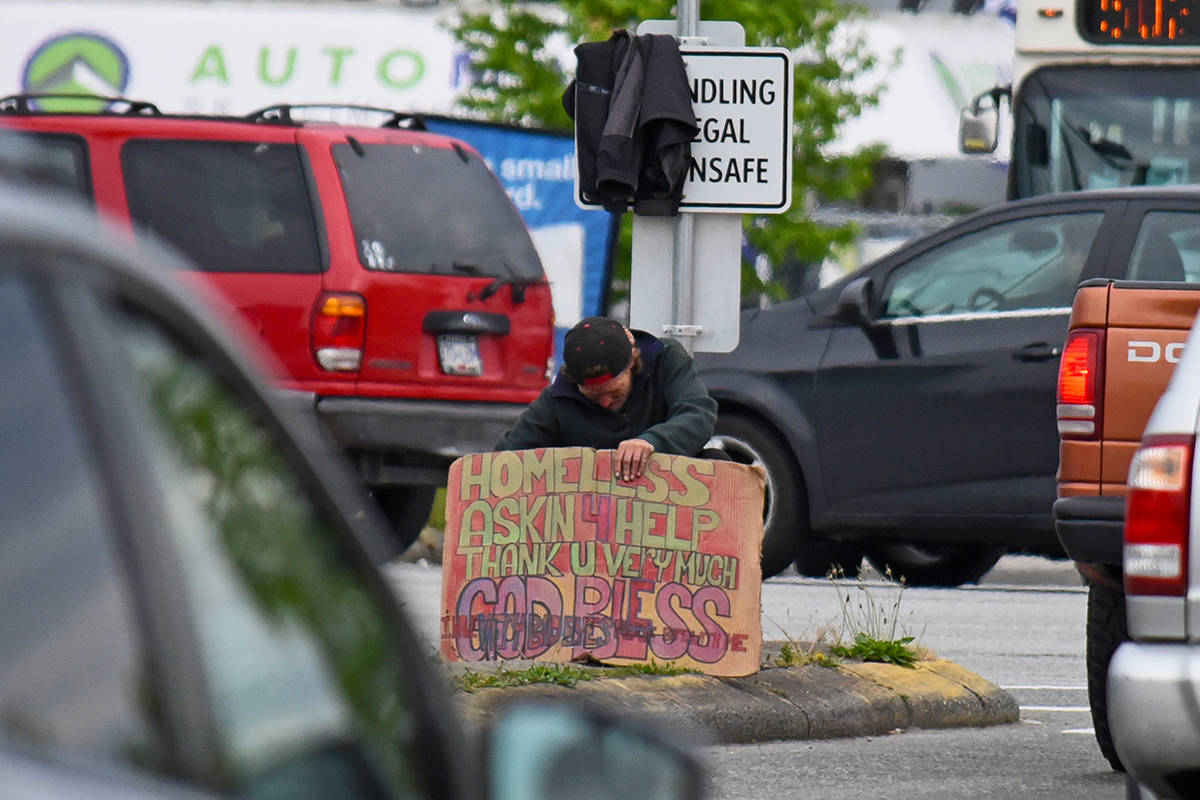 A panhandler has thrown a jacket on top of a sign that reads “panhandling is illegal and unsafe” on Fraser Highway at the Langley Bypass. According to the 2017 homeless count, 206 homeless people live in the Langleys. Langley Times file photo