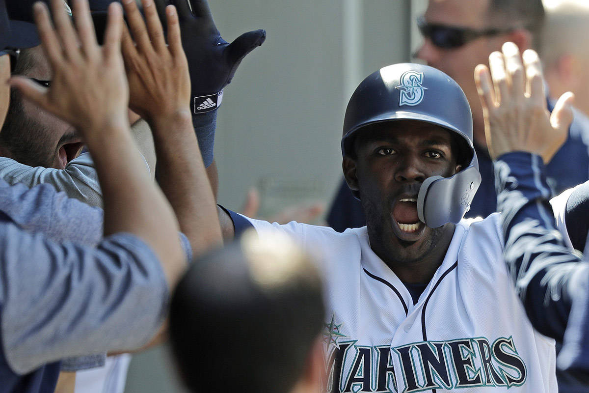 Seattle Mariners’ Guillermo Heredia is congratulated in the dugout after he scored against the San Francisco Giants during the eighth inning of a baseball game Wednesday, July 25, 2018, in Seattle. The Mariners won 3-2. (AP Photo/Ted S. Warren)