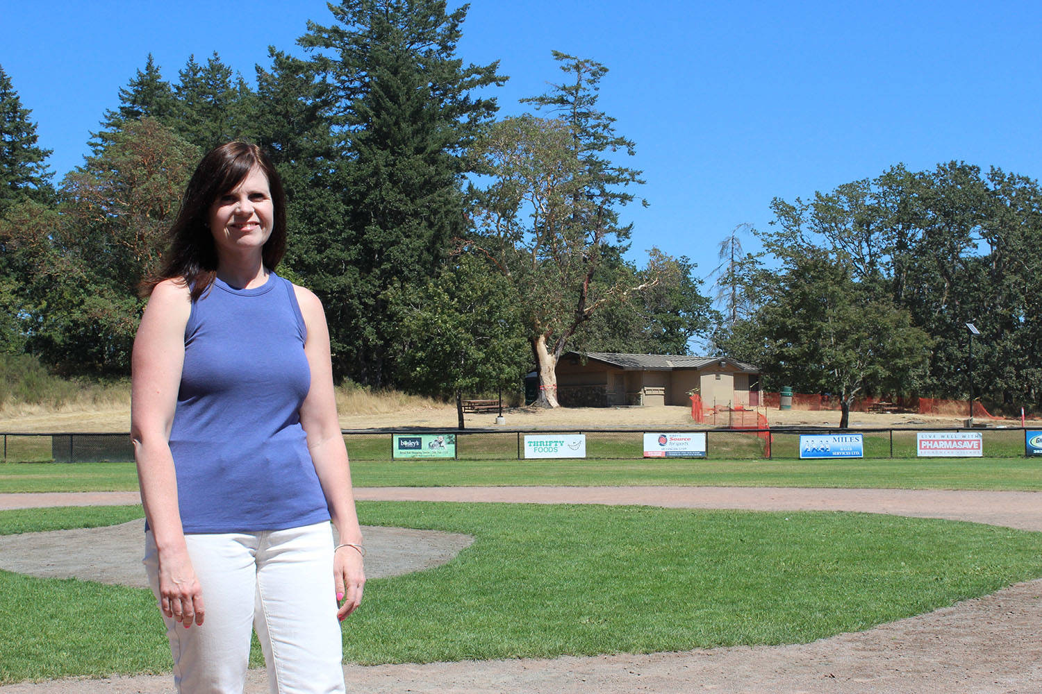 Shannon Nakatsu, acting president of Layritz Little League, stands on one of the diamonds at the park, with the now closed washroom in the background. (Dan Ebenal/News Staff)