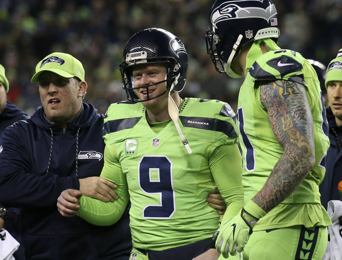 Seahawks punter Jon Ryan is helped off the field after a 50-yard run at CenturyLink Field Thursday night in Seattle on Dec. 15, 2016. (Kevin Clark/The Herald)