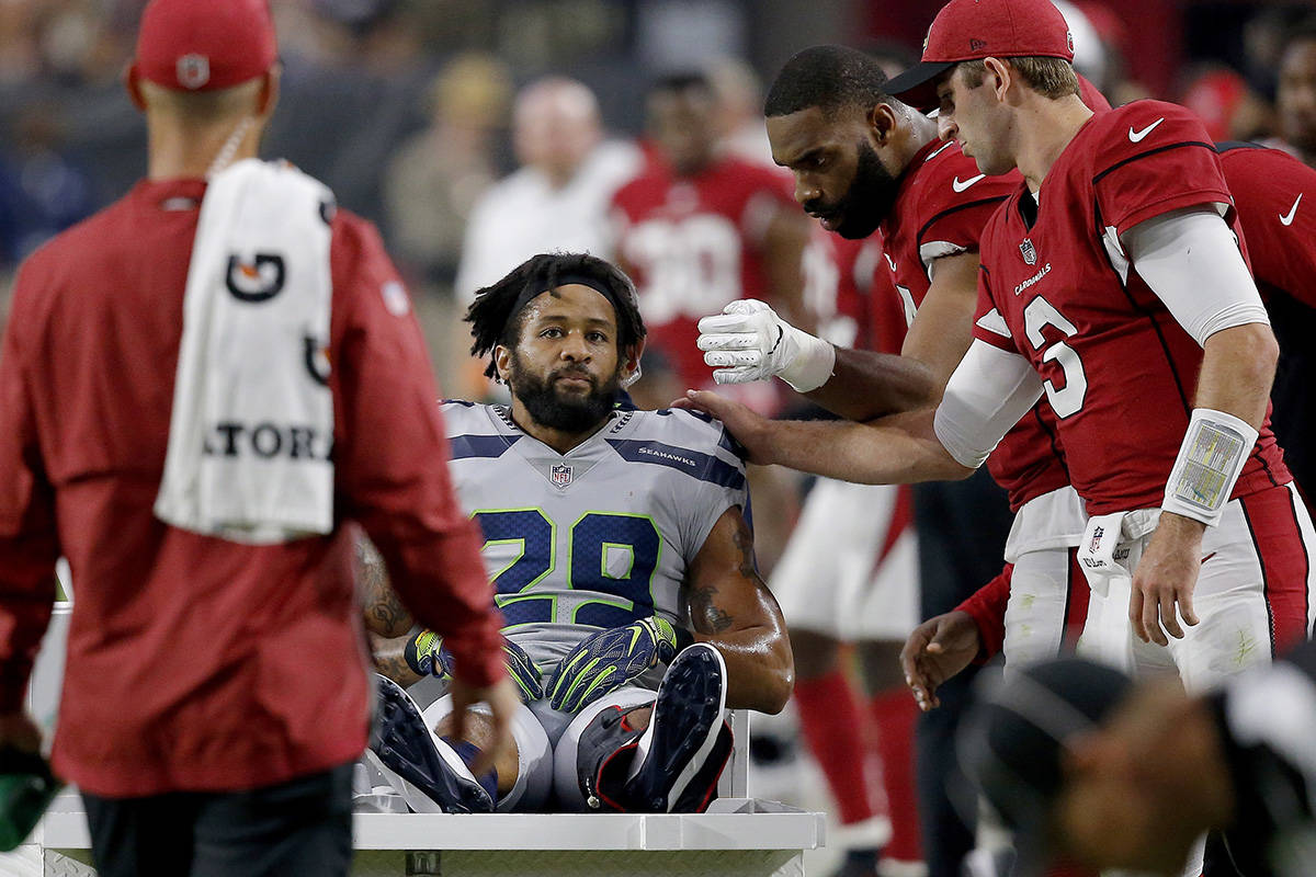 Seattle Seahawks defensive back Earl Thomas (29) is greeted by Arizona Cardinals players as he leaves the field after breaking his leg during the second half of an NFL football game, Sunday, Sept. 30, 2018, in Glendale, Ariz. The Seahawks won 20-17. (AP Photo/Ross D. Franklin)