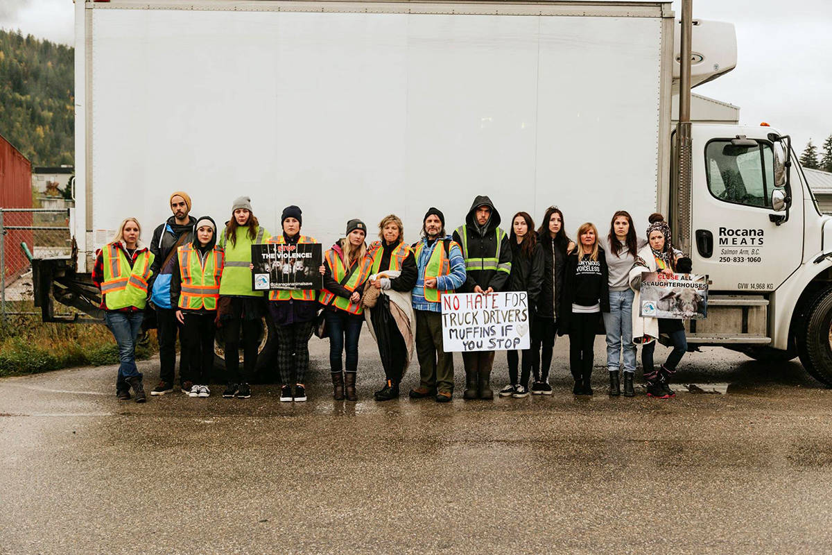 A group of activists with the Okanagan Animal Save group come together around a Rocana Meats delivery truck for a photo during a protest at the company’s facility in Salmon Arm Monday, Oct. 1. (Facebook/Okanagan Animal Save)