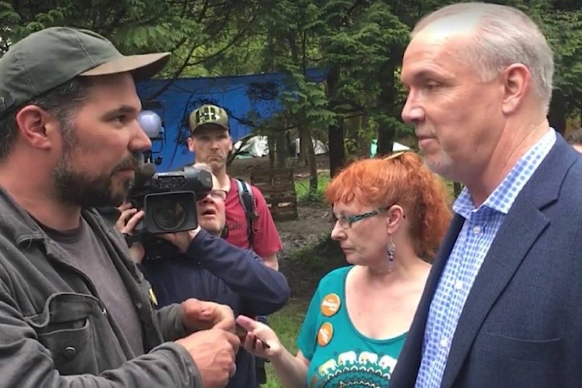 Which one of these guys runs B.C.’s supportive housing policy? Squat organizer Ivan Drury demands housing from NDP leader John Horgan after crashing his campaign event in Maple Ridge, May 2017. The B.C. government is leaving thousands of people on its waiting list while it rushes to satisfy squatter demands. (Michael Hall/Maple Ridge News)