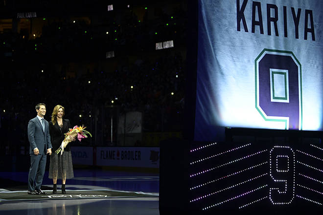 Former Anaheim Ducks player Paul Kariya, left, stands with his girlfriend Valerie Dawson and watches as his jersey is retired prior to an NHL hockey game against the Buffalo Sabres, Sunday, Oct. 21, 2018, in Anaheim, Calif. (AP Photo/Mark J. Terrill)