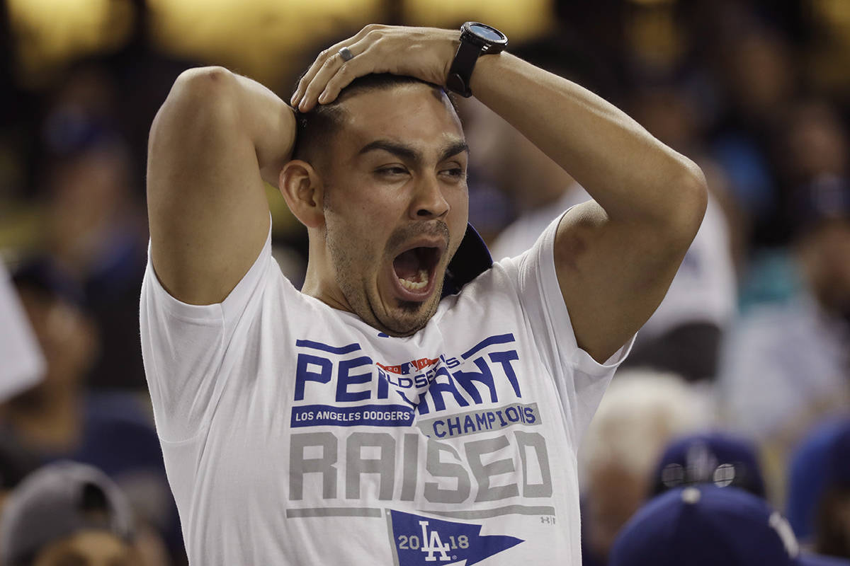 A fan yawns before the start of the 17th inning in Game 3 of the World Series baseball game between the Boston Red Sox and Los Angeles Dodgers on Friday, Oct. 26, 2018, in Los Angeles. (AP Photo/David J. Phillip)