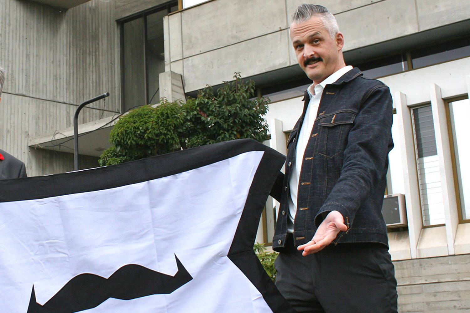 Adam Flint, a member of Saanich Planning and the co-chair for the Movember Victoria chapter, holding the Movember flag at Saanich municipal hall. (File photo)